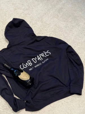 CLUB D’APRÉS Hoodie - Säljer en schysst blå hoodie med tryck både fram och bak. Skick: 10/10. Storlek M passar S / M. Nypris: 949. 