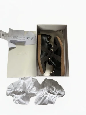 Maison Margiela Gats - Säljer ett par sjukt snygga maison margiela gats i storlek 43. De är i princip i nyskick och allt og följer med som box,dustbag osv. Nfc på sulan under skon fungerar och farfetch tag följer med. Skriv vid frågor eller funderingar! Fraktar inom 24 timmar (instabox).