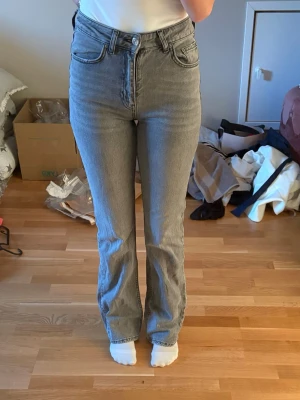 Gråa flare jeans från gina tricot - Jättefina gråa jeans i flare modell med mellanhög midja från gina tricot. Jeansen är knappt använda och har inga defekter💞 Skriv vid eventuella frågor!