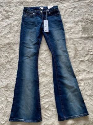 Blå flared jeans från Gina Tricot - Säljer ett par blå flared jeans från Gina Tricot i storlek XS. Är aldrig använda eller provade!