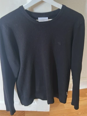 Svart slim fit tröja från Lindbergh - En stilren svart långärmad tröja från Lindbergh i slim fit-modell. Tröjan har rund halsringning och är tillverkad i ett mjukt, stickat material som passar perfekt till en avslappnad men ändå snygg look. Jag köpte tröjan ny i butik för 700 kr och den är ganska oanvänd och är i väldigt bra skick.