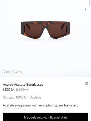 Bruna solglasögon från Filippa K - Snygga solglasögon från Filippa K med markerad, fyrkantig båge i brunmelerad acetat och mörka linser. Modellen har en trendig, kantig form och logga på skalmen. Perfekt accessoar för att lyfta din stil.