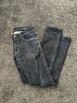 Mörkblå slim jeans slimfit  - Snygga mörkblå slim fit jeans från Crocker med klassisk femficksdesign och silverfärgade nitar. Jeansen har slim passform och är tillverkade i ett stretchigt denimtyg som sitter skönt hela dagen. Storlek W29 L32