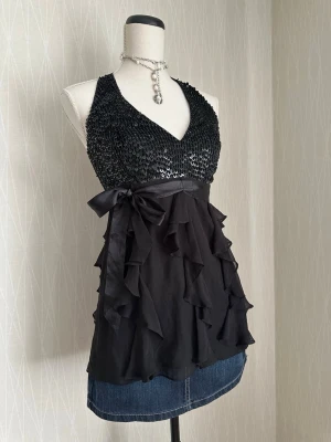 Svart paljet halter neck topp med volanger och rosett - Svart paljet halter neck topp med volanger och rosett passar S/XS