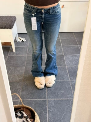 Blå bootcut jeans - Säljer ett par snygga blå bootcut jeans med klassisk femficksmodell och låg midja. Storlek 164 men passar XS/S. 