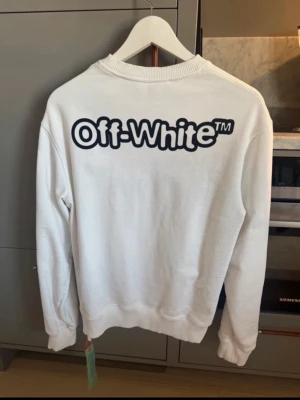 Vit sweatshirt från Off-White - Vit sweatshirt från Off-White med svart logotyptryck både fram och stort på ryggen. Size M men passar mig som är 186cm lång. Perfekt till sommaren!! Köpt i OFF-White butiken i Milano. 