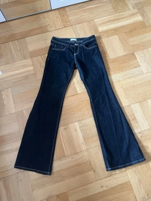 Mörkblå bootcut jeans - Snygga mörkblå bootcut jeans från Gina Tricot med kontrasterande vita sömmar.  Använda fåtal gånger och slutsålda på hemsidan💕 Klassisk femficksmodell och låg midja. Perfekta för dig som gillar en retroinspirerad look. Tillverkade i denim med lite stretch för extra komfort.