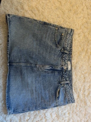 Blå jeanskjol från Gina Tricot - Super fin blå jeanskjol ifrån Gina tricot med fickor där bak, använd ungefär två gånger. Väldigt fint skick, hör gärna av dig om frågor💕