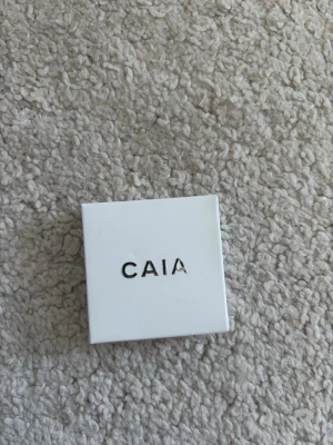 Oöppnad CAIA Extra Fizz ögonskugga - Säljer en ögonskugga från CAIA i färgen Extra Fizz. Förpackningen är fyrkantig och vit med stilren design. Perfekt för dig som vill ha en snygg och pigmenterad ögonskugga i sminkväskan. Nypris: 175kr