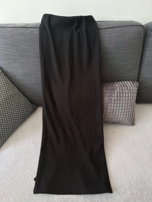 Svart kjol med slits bak - Lång svart kjol med fin slits bak. Köpt på gina tricot i storlek XS. Använts ett fåtal gånger men inga fel på den. 💓
