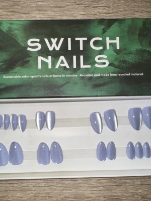 Switch Nails Blue Cat Eye mandelform - Press-on naglar från Switch Nails i modellen Blue Cat Eye. Naglarna har en snygg blå nyans med skimrande cat eye-effekt och är i kort mandelform. Tillverkade av återvunnet material och kan återanvändas. Perfekt för dig som vill ha salongskänsla hemma. Säljes utan tillbehör.