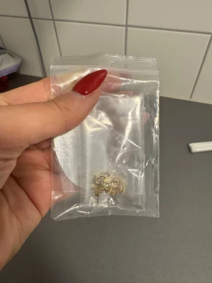 Guldiga örhängen pläterade 18k - Snygga små örhängen i guldton med glittrande pärldetaljer. Perfekta för att ge din look lite extra bling. Kommer i en försluten plastpåse. Pläterade i 18k guld