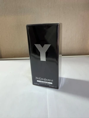 Yves Saint Laurent Y Le Parfum 100ml - Y Le Parfum från Yves Saint Laurent är en lyxig parfym i en stilren svart rektangulär flaska med en stor silverfärgad Y på framsidan. Förpackningen är elegant och modern, perfekt för dig som gillar exklusiva dofter. Volymen är 100 ml.