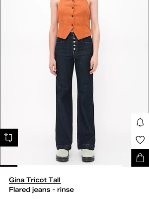 Flared jeans från Gina Tricot - Mörkblå flared jeans från Gina Tricot Tall med hög midja och synliga silverknappar framtill. Säljer pga att de är lite för korta på mig. Jag är 167. Skulle rekommendera för någon som är 165 eller kortare. Använda men i väldigt bra skick. Storlek 36