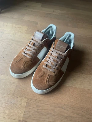 Valentino Flycrew sneakers i brun mocka – Strl 40 - Säljer ett par Valentino Flycrew i brun mocka, storlek 40. I jättefint skick och knappt använda. Alla nitar sitter kvar.  Nypris ca 7 000 kr. Modellen är ovanlig och säljs sällan.  Köpta från seriös butik. Originalkartong finns tyvärr inte kvar, men jag skickar gärna fler bilder vid behov.  Öppen för rimliga bud. Skriv gärna vid frågor. 