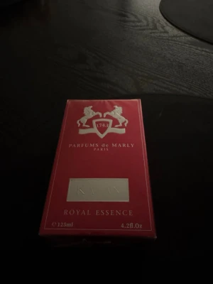 Parfums de Marly Kalan EdP 125ml - Lyxig parfym från Parfums de Marly i serien Royal Essence, modellen Kalan. Förpackningen är röd med silverdetaljer och logotyp med två hästar. Innehåller 125 ml Eau de Parfum. Perfekt för dig som gillar exklusiva och eleganta dofter. Ny pris ca 3100kr. Pris kan diskuteras.