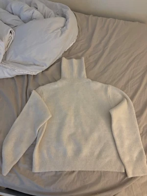 Krämvit polotröja i stickat material - Mysig beige stickad polotröja. Tröjan har en rak passform och ribbstickade muddar vid ärmslut och nederkant. Från Zara, skulle säga att den passar som en xxs.💕