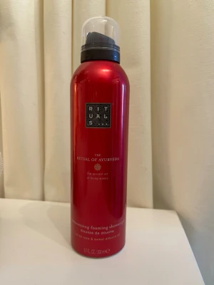 Rituals The Ritual of Ayurveda duschskum - Lyxigt duschskum från Rituals i serien The Ritual of Ayurveda. Flaskan är metallicröd med svart lock och innehåller 200 ml. Produkten har doft av indisk ros och sötmandelolja och ger ett rikt, skummande lödder. Öppnad men ej använd :)
