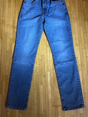 Levi’s 724 High-Rise Straight – Vintage Stretch - Snygga och bekväma Levi’s 724 High-Rise Straight i klassisk blå denim. Hög midja och rak passform som sitter fint över höfter och lår – tidlös modell som funkar till allt. Tillverkade i Levi’s Vintage Stretch-denim för både komfort och en autentisk jeanslook. Jeansen är i ny skick aldrig använda.  💙 Original Levi’s 💙 Modell: 724 High-Rise Straight 💙 Hög midja, rak benform 💙 Bekvämt stretchmaterial 💙 Nypris ca 1 349 kr Pris: 599 kr 