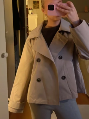Beige trenchcoat - Trendig kort trenchcoat i beige ❤️‍🔥❤️‍🔥 passar 36/38, vet inte vart den är ifrån! Köpte second hand 