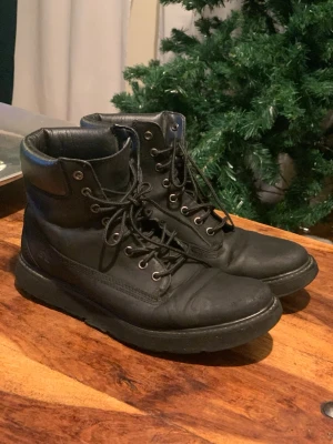 Svarta läderkängor Timberland - Säljer ett par svarta kängor från Timberland i äkta läder. Klassisk snörning med metallöljetter och vadderad kant upptill för extra komfort. Snygg och tidlös modell som passar till många olika stilar.