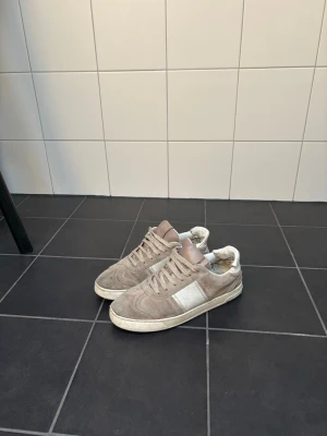 Valentino flycrew  - Snygga Valentino flycrew  i beige mocka med vita detaljer och snörning defekt i hälen däremot.