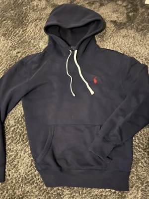 Mörkblå hoodie från Polo Ralph Lauren - Säljer en riktigt fet slim fit hoodie från Ralph Lauren, då den tyvärr blivit för liten för mig. Den är i storlek S. Den är sparsamt använd och har få tecken på deflekter. 