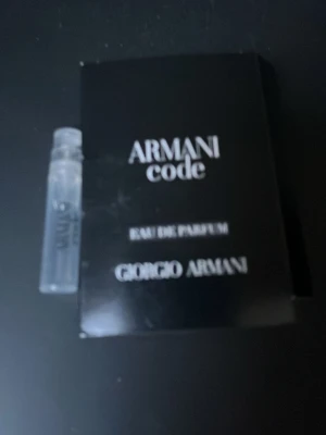 Armani Code Eau de Parfum provflaska - En liten provflaska av Armani Code Eau de Parfum från Giorgio Armani. Flaskan är genomskinlig med svart text och kommer i en elegant svart kartong med vit text. Perfekt för dig som vill testa en lyxig och ikonisk doft.