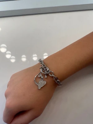 Silverfärgat armband  - Säljer detta stilrent armband i silverfärgad metall med ett gnistrande hjärthänge dekorerat med små stenar🫶🏼🫶🏼