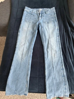 Gina tricot - ljusblå utsvängda jeans - Snygga ljusblå jeans med utsvängda ben och två framfickor. Jeansen har markerade sömmar längs benen och klassisk knappgylf. Gina tricot young, mycket fint skick!