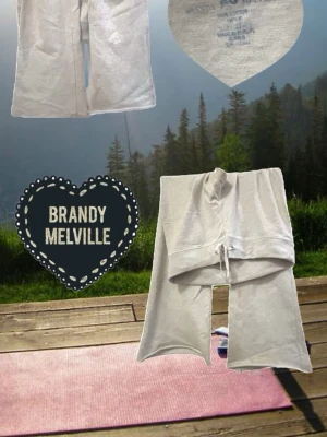Grå mjukisbyxor från Brandy Melville - Säljer ett par ljusgrå mjukisbyxor från Brandy Melville med breda ben och dragsko i midjan. Tillverkade i mjukt bomullsmaterial som är riktigt skönt mot huden. Perfekta för chill dagar eller när du vill ha en avslappnad look.