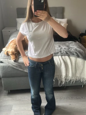 Vit croppad t-shirt med stjärna - Vit kort t-shirt med trycket 'MA CHÉRIE' och en stjärna på framsidan. T-shirten har är ifrån Gina tricot i storlek 134/140