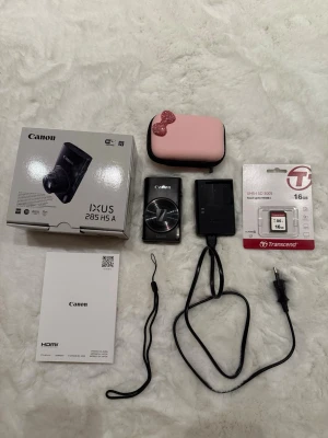 Canon Ixus 285 Hs / Elph 360 / IXY 650 - Canon IXUS 285 HS kamera 📷  På bilderna syns originalkartong, handledsrem, laddare med nätkabel, ett minneskort på 16 GB samt ett rosa fodral.  Köpt för 4 månader sen och använd få gånger, i mycket bra skick. Säljes då jag inte fotar lika mycket längre, annars är den verkligen värd och tar fina bilder. Väldigt kompakt! 💕  Ord pris: 4 690 kr
