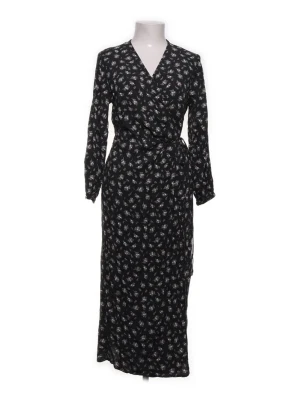 Svart blommig omlottklänning - H&M - Snygg svart långklänning med små vita blommor och omlottmodell. Klänningen har v-ringning, långa ärmar och knyt i midjan för en smickrande siluett. Perfekt för dig som gillar en feminin och trendig stil. (Etikett saknas)