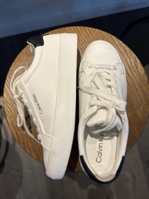 Vita sneakers från Calvin Klein - Stilrena vita sneakers från Calvin Klein  Diskret Calvin Klein-logga på sidan och innersulan. Använda 2 gånger säljer pågrund av för små