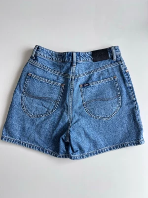 Lee y2k/90s high waist denim shorts strl S – klassisk blå tvätt - Vintage premium Y2K Lee denim shorts i perfekt 90s blue wash. Klassisk clean modell med hög midja. Så snygga med baby tee, linne eller oversized hoodie! Oanvända, inköpta i Australien.   Storlek: AUS 8 (motsvarar S / EU 36)  Midja: ca 73 cm  Skick: Nytt, inga hål eller fläckar ✨ Nypris: 700kr