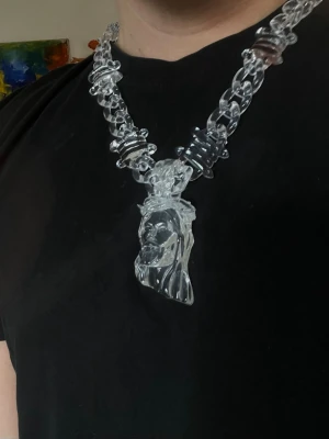 Vleat chain med Jesus-hänge i ”glas” - Säljer mitt halsband med transparant kedja och ett stort hänge i  av Jesus , allt i glasliknande material. 