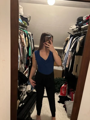 Blå ärmlös topp med v-ringning - Snygg blå topp med v-ringad hals och ärmlös design. Toppen har en enkel och stilren look som passar perfekt till både jeans och kjol. Materialet känns mjukt och följsamt mot kroppen. Perfekt för dig som vill ha en basic men ändå trendig topp.