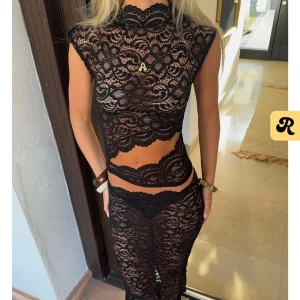 Svart spetsig croppad topp - Säljer en svart croppad topp i genombruten spets med hög hals och korta ärmar. Toppen har ett feminint mönster och är perfekt för dig som vill sticka ut. Snygg att styla med höga byxor eller kjol.                           Toppen är i storlek M/L men tror den även passar för de som vanligtvis har S! Endast testad, prislapp är kvar