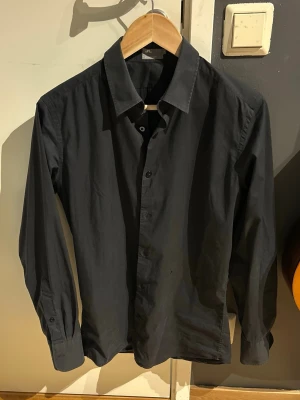 Svart skjorta J.Lindeberg - Klassisk och stilren svart skjorta från J.Lindeberg i Small. Väldigt fint skick. Perfekt för en clean och enkel look.
