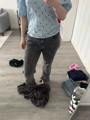 Grå raka jeans med vintagekänsla - Säljer ett par grå jeans med rak passform och hög midja. Jeansen har klassisk femficksdesign och en tvättad vintage-look. Perfekta för dig som gillar en avslappnad och trendig stil. Materialet är kraftig denim i bomull.