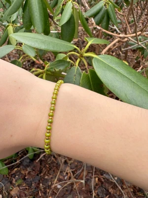 Grönt pärlarmband - Snyggt armband med små, runda gröna pärlor på elastisk tråd. Perfekt för dig som gillar enkla men färgglada accessoarer. Passar till många olika stilar och är lätt att matcha med andra smycken.