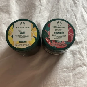 Body Yogurt Mango & Strawberry - Två burkar Body Yogurt från The Body Shop i dofterna Mango och Strawberry. Båda är veganska och passar normal till torr hud. Innehåller 200 ml vardera och ger 48h fukt. Burkarna är gröna med färgglada lock och tillverkade av återvunnet material. En kostar 100, båda 200.