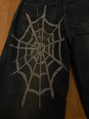  Baggy Jeans med Strass - Blåa baggy/vida jeans från Shein med spindelnät mönster i strass💕 LAPPEN KVAR! Säljer då de inte passade. Se mått på bild 4. Köpa för 339kr 🌟 Skriv vid frågor! Pris kan diskuteras vid snabb affär💫