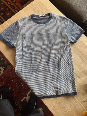 Randig t-shirt från Roy Robson - Snygg randig texturerad t-shirt från Roy Robson i blått och vitt. Ribbade muddar vid hals och ärmslut. Storlek M, lite blekt från tvättning