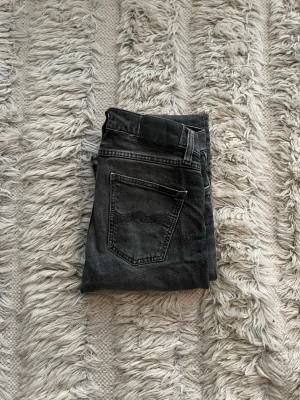 Svarta slim jeans från Nudie Jeans - Snygga svarta slim fit jeans från Nudie Jeans, Lean Dean, med klassisk femficksdesign och diskreta sömmar på bakfickorna. Jeansen har en mörk tvätt och är tillverkade i mjukt denimtyg som sitter skönt hela dagen. Storlek 29,32