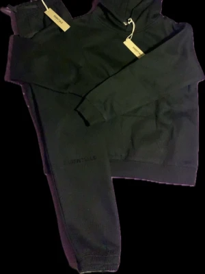 Svart hoodie Essentials Fear of God - Svart hoodie från Essentials Fear of God helt ny fick den som present har redan ett par därför säljs billigt! Snabb frakt med instabox storlek M men passar S-xxs pågrund av att dom är baggy om man gillar baggy fit! Pris kan diskuteras vill att den ska säljas bort snabbt inga konstigheter! Ta instabox för snabb&smidig leverans (2-3 arbetsdagar efter dom har tagit emot paketet)