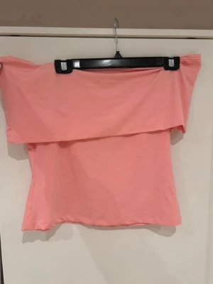 Ljusrosa offshoulder topp - Trendig ljusrosa offshoulder topp med bred volangkant upptill. 