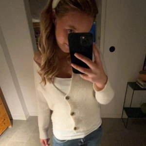 Beige stickad kofta med knappar - Mysig beige stickad kofta med v-ringning och stora knappar framtill. Hadde viljat ha kvar den men den passar inte mig längre.