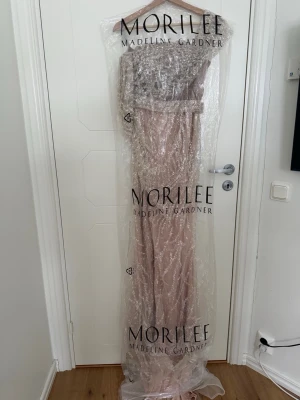 Glittrig långklänning från Morilee - Säljer en fin rosa Bech glittrig klänning perfekt för fester. Den är använd i några timmar passar storlek 36-38 köpt för 9000